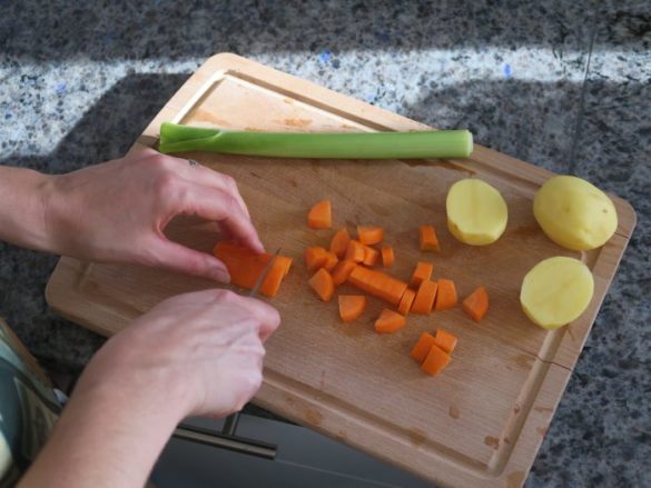 Zutaten für Linsensuppe wie Kartoffeln, Karotten und Lauch klein schneiden